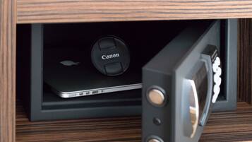 Un armario de madera con una cámara Canon y una laptop en su interior.