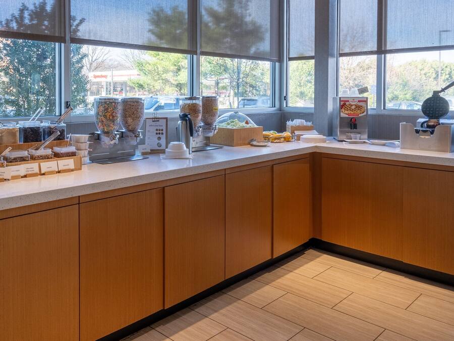 A modern kitchen with a large window, wooden cabinets, and various food dispensers.