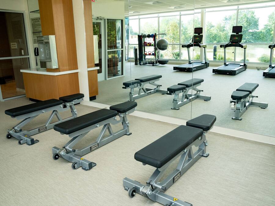 A gym with treadmills, weight benches, and a water dispenser.