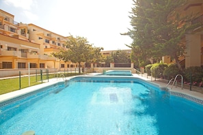 A swimming pool surrounded by apartment buildings with balconies.