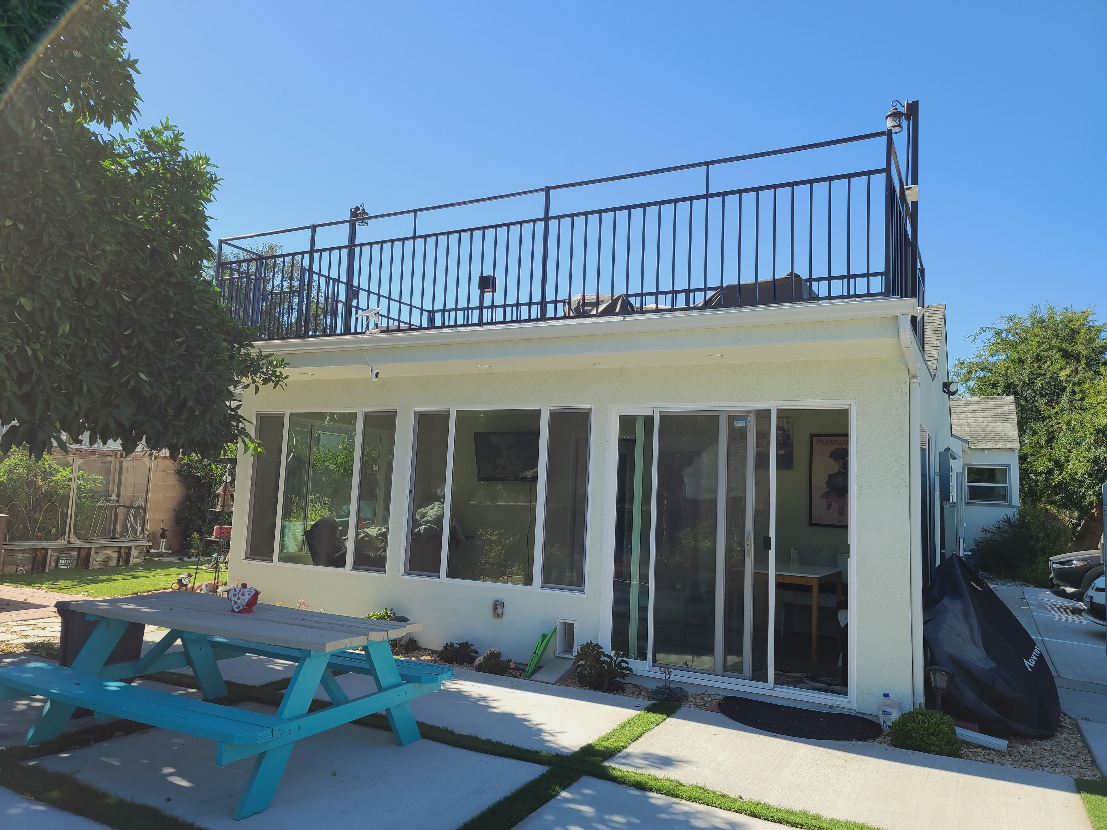Een huis met balkon, een terras met een tafel en een garage.