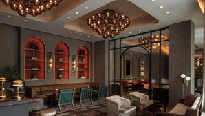 A modern lobby with a bar area, seating, and decorative lighting. - The Tess, Autograph Collection (Atlanta)