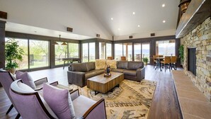 Un salón espacioso con un sofá modular grande, una mesa de centro y una chimenea.