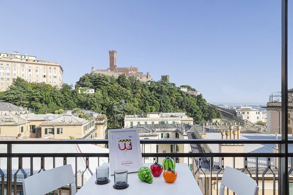 A balcony with a table, chairs, and a sign welcoming to a wonderful Italy home.
