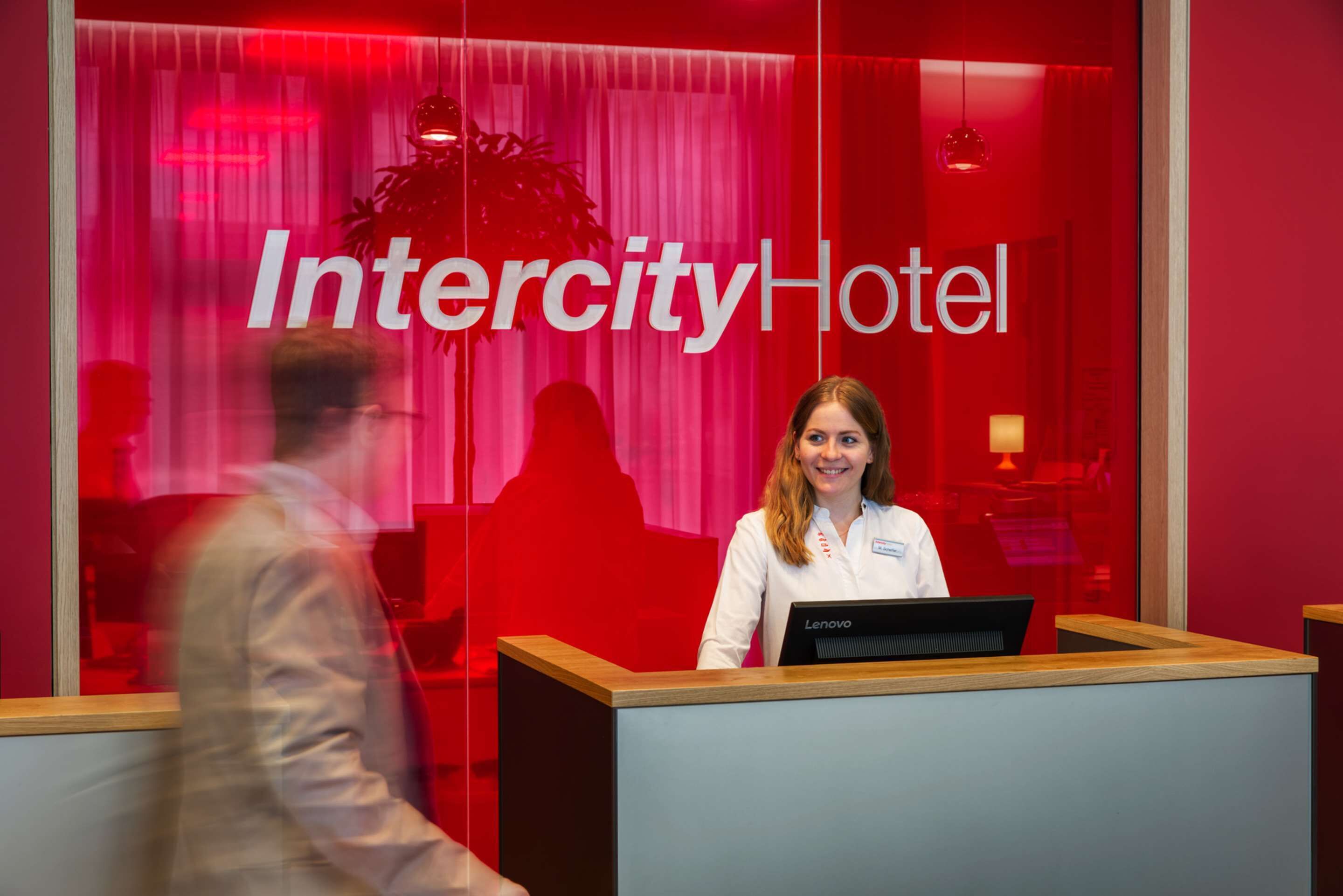 A reception desk with a sign reading "Intercity Hotel" in the background.