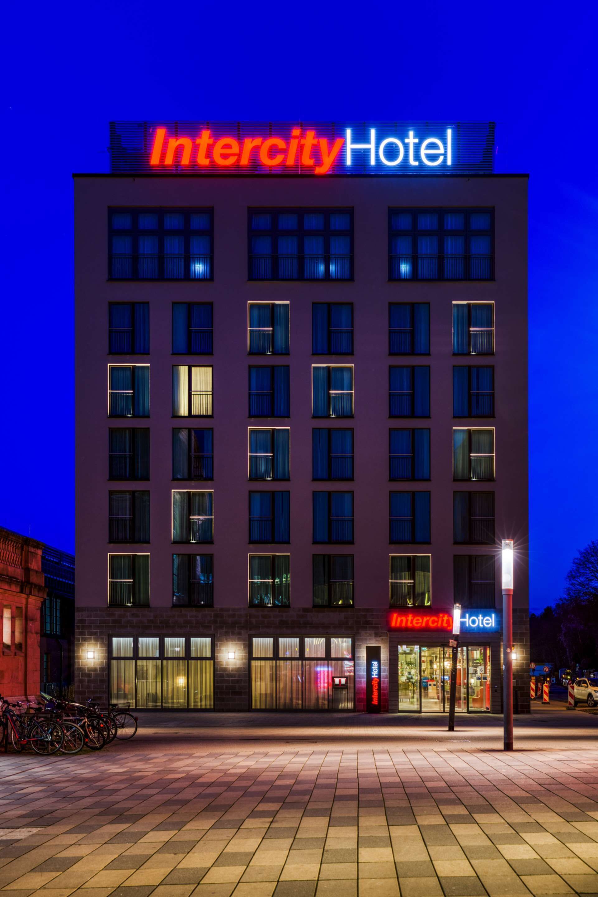 A modern Intercity Hotel building with a prominent sign, large windows, and a paved entrance area.