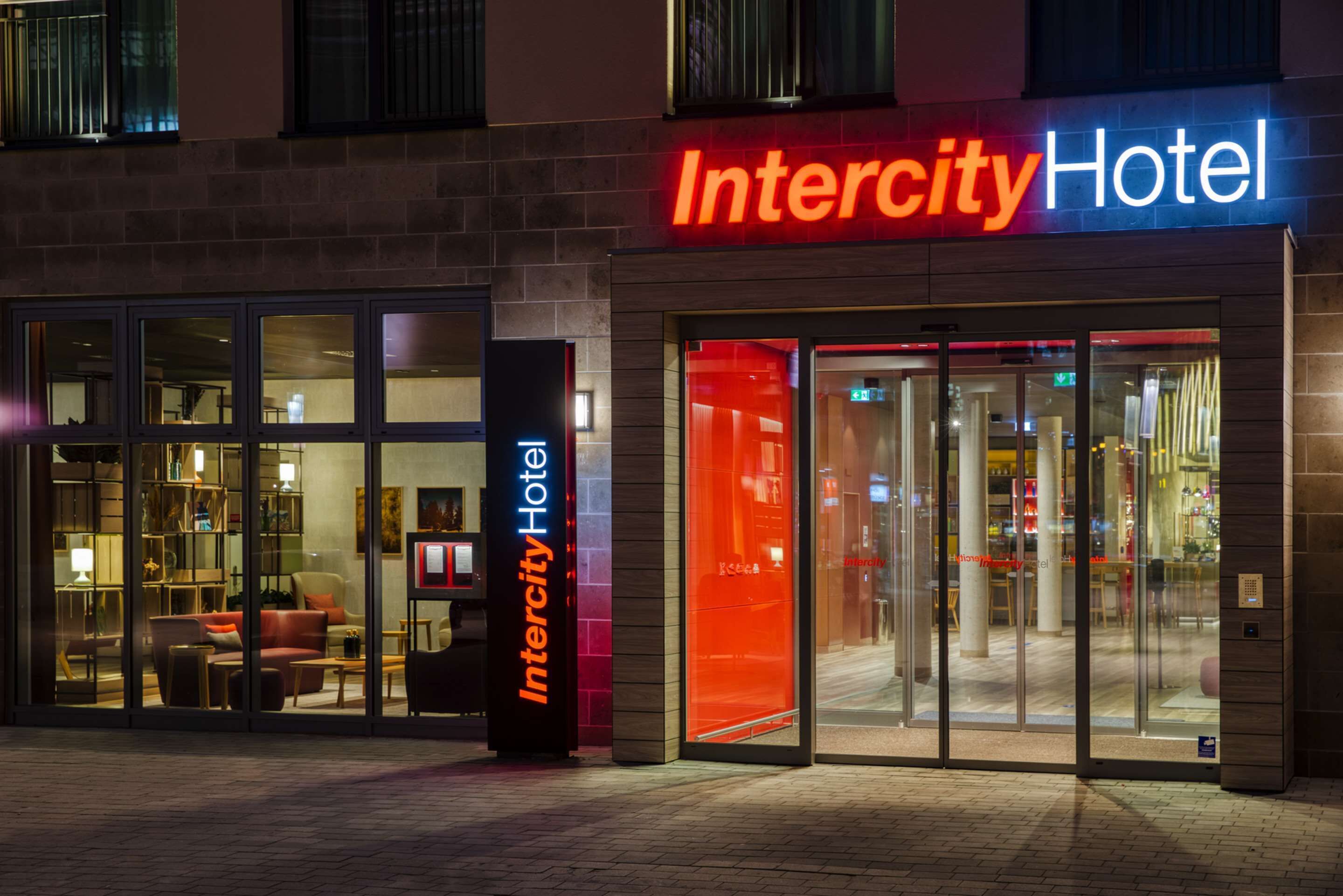 Das Intercity Hotel mit moderner Architektur, mit Glastüren und einem gut beleuchteten Eingangsbereich.
