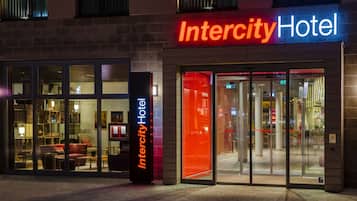 Das Intercity Hotel mit moderner Architektur, mit Glastüren und einem gut beleuchteten Eingangsbereich.