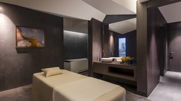 A modern hotel room with a large bed, a built-in vanity with a mirror, and a painting on the wall.