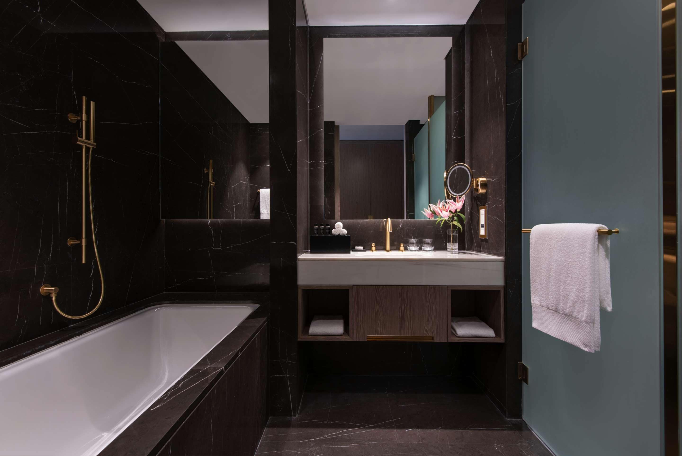 A modern bathroom with a freestanding bathtub, a vanity with a mirror, and a towel rack.