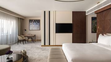Una habitación de hotel moderna con una cama grande, un escritorio y un área de descanso.