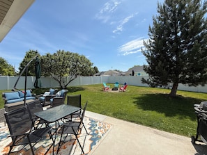 A patio with outdoor furniture, a swing, and a tree. - Cozy multi family home with lots of space to keep everyone entertained! (Boise)