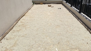 A rooftop with a gravel surface, a pink hoop, and a black fence. - Villa Avec Piscine, Jacuzzi et vue Imprenable sur la Garigue (Saint-Paul-et-Valmalle)