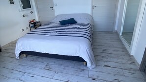 A bedroom with a bed, a small bedside table, and a wardrobe. - Villa Avec Piscine, Jacuzzi et vue Imprenable sur la Garigue (Saint-Paul-et-Valmalle)