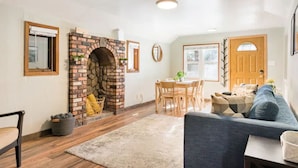 Ein gemütliches Wohnzimmer mit Kamin, Holzmöbeln und einem Essbereich.