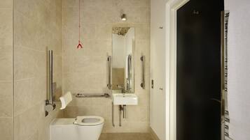 Un baño moderno con inodoro, lavamanos y ducha.