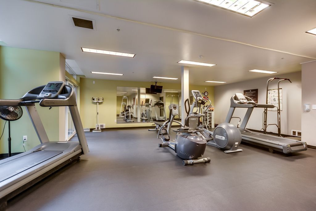 A gym with treadmills, elliptical machines, and weight equipment.