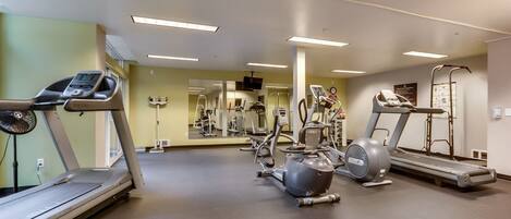 A gym with treadmills, elliptical machines, and weight equipment.