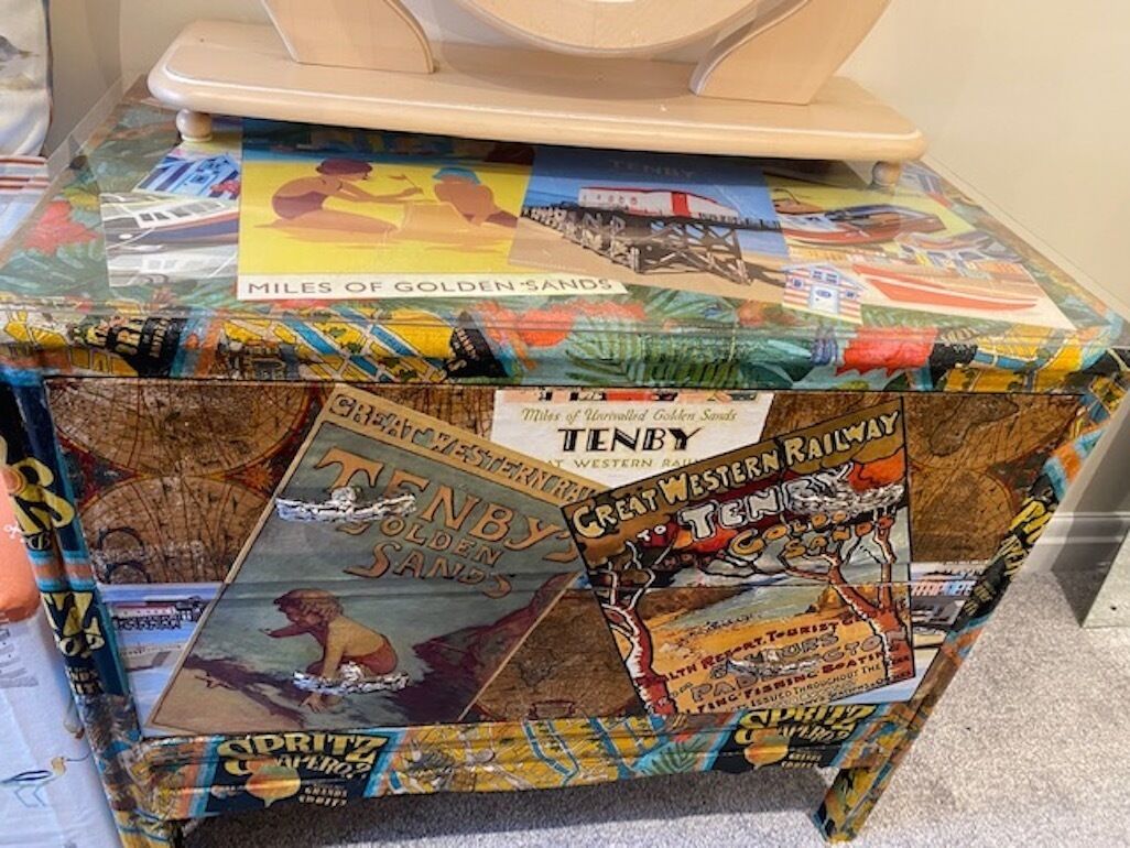 A table covered with various travel-themed posters and stickers.