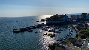 A coastal town with a marina, buildings with colorful facades, and a clear view of the sea.