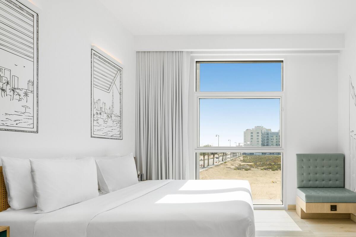 Ein modernes Schlafzimmer mit einem großen Bett, Meerblick und einem Balkon.