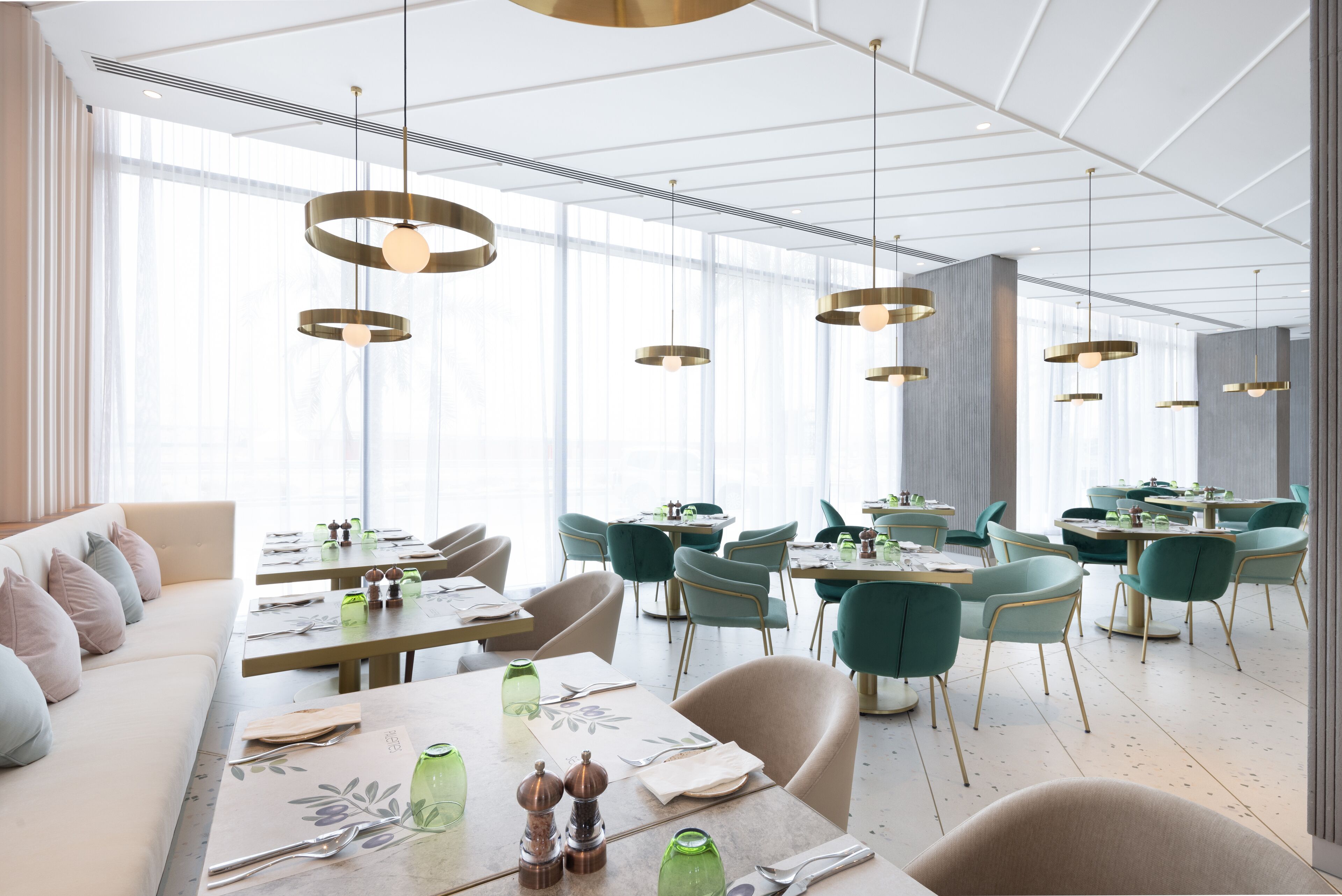 A modern dining area with tables, chairs, and pendant lighting.