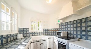 Eine Küche mit weißen Schränken, einer Mikrowelle, einem Backofen und einem Geschirrspüler.