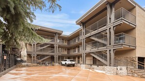 A multi-story building with a central courtyard, outdoor stairs, and a white vehicle parked in the middle. - BRIGHT, Renovated, In the Heart of Aspen Walkable (Aspen)