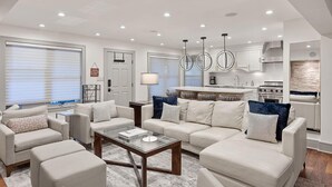 A modern living room with a sofa set, a coffee table, and a kitchen in the background. - BRIGHT, Renovated, In the Heart of Aspen Walkable (Aspen)