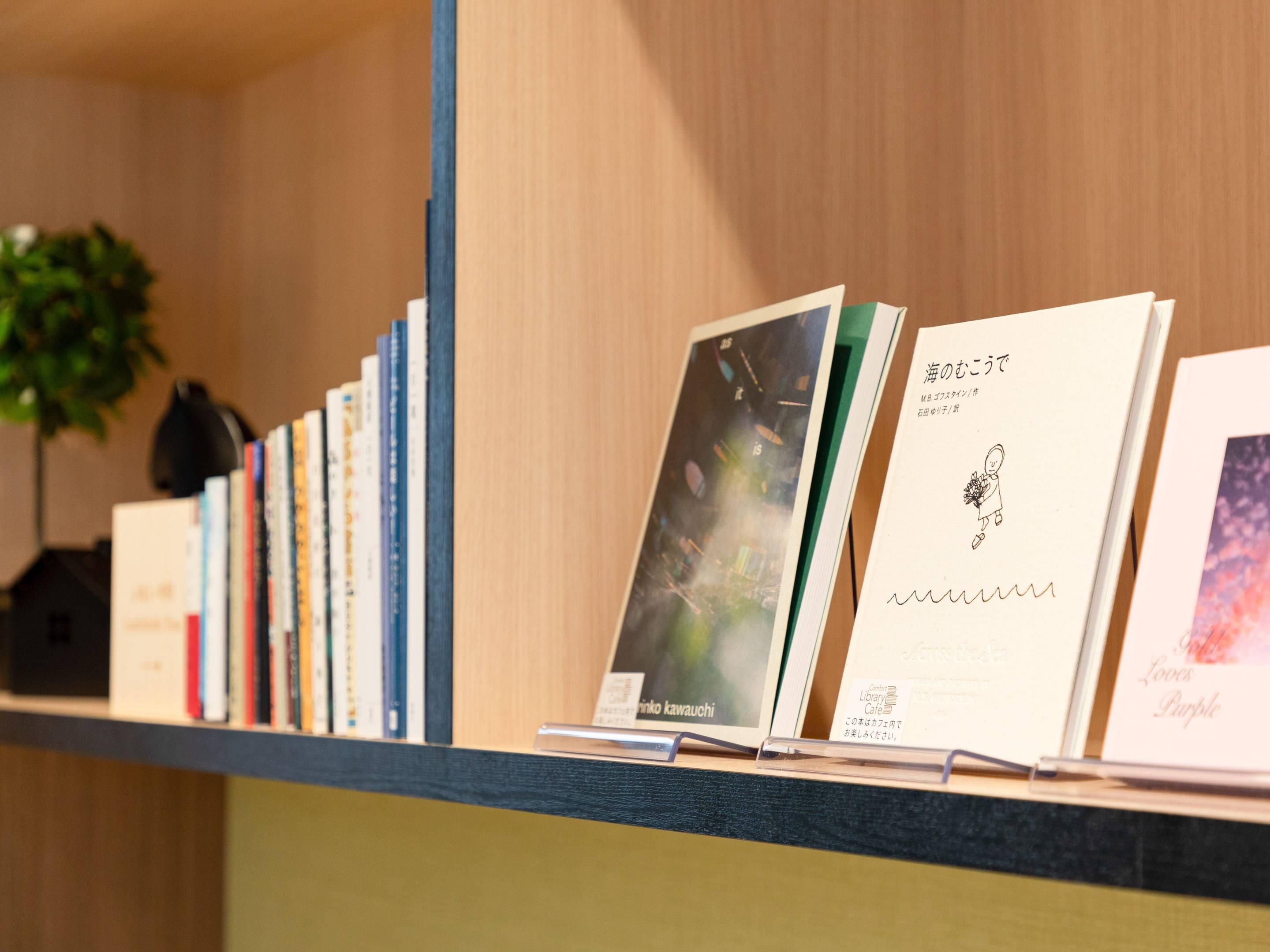 Uma estante com livros e um quadro emoldurado.
