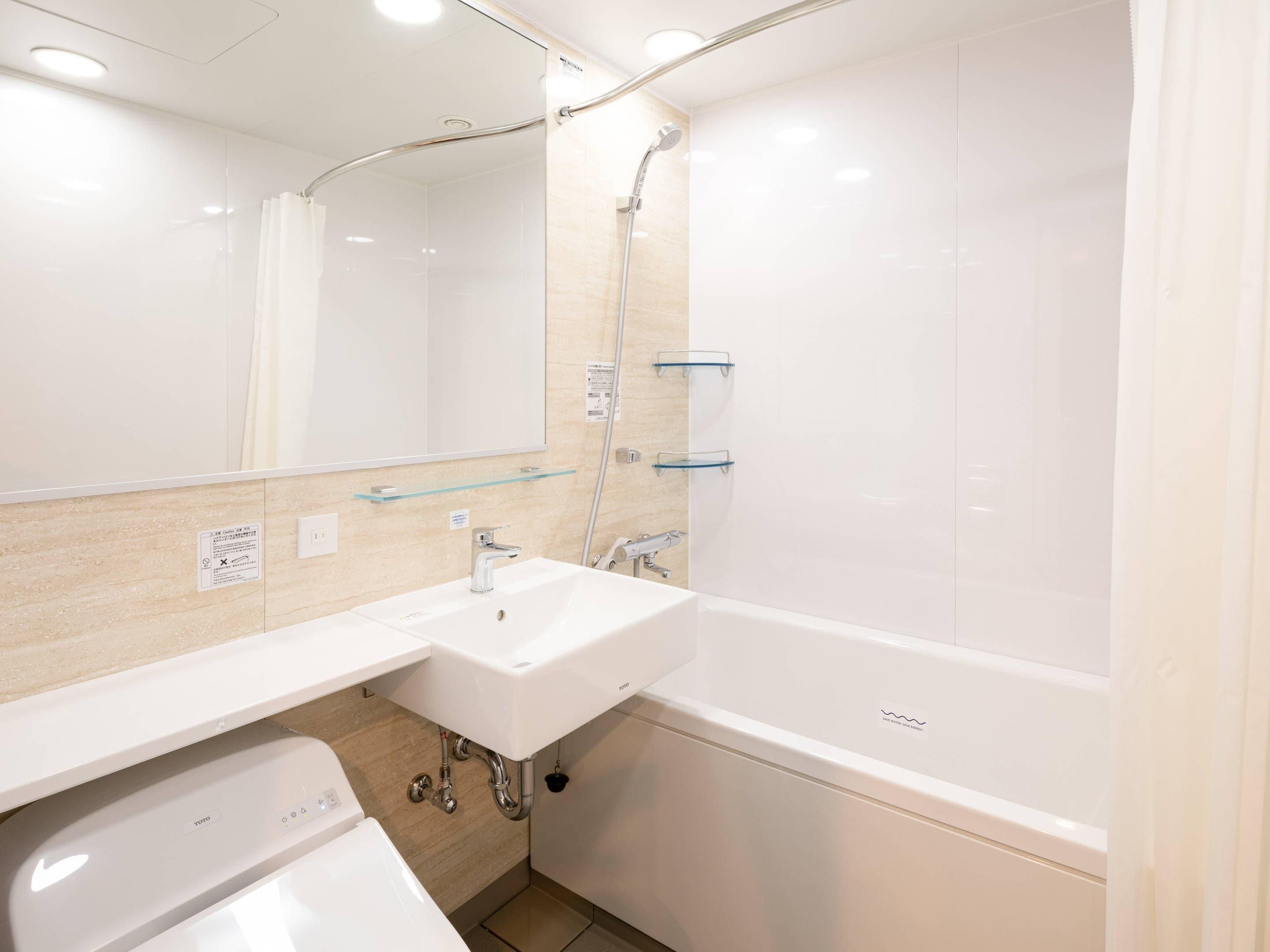 Een moderne badkamer met een wit wastafelmeubel, spiegel en douche.