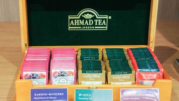 Une sélection de produits AHMAD TEA présentée dans une boîte en bois, avec des étiquettes en anglais et en japonais.