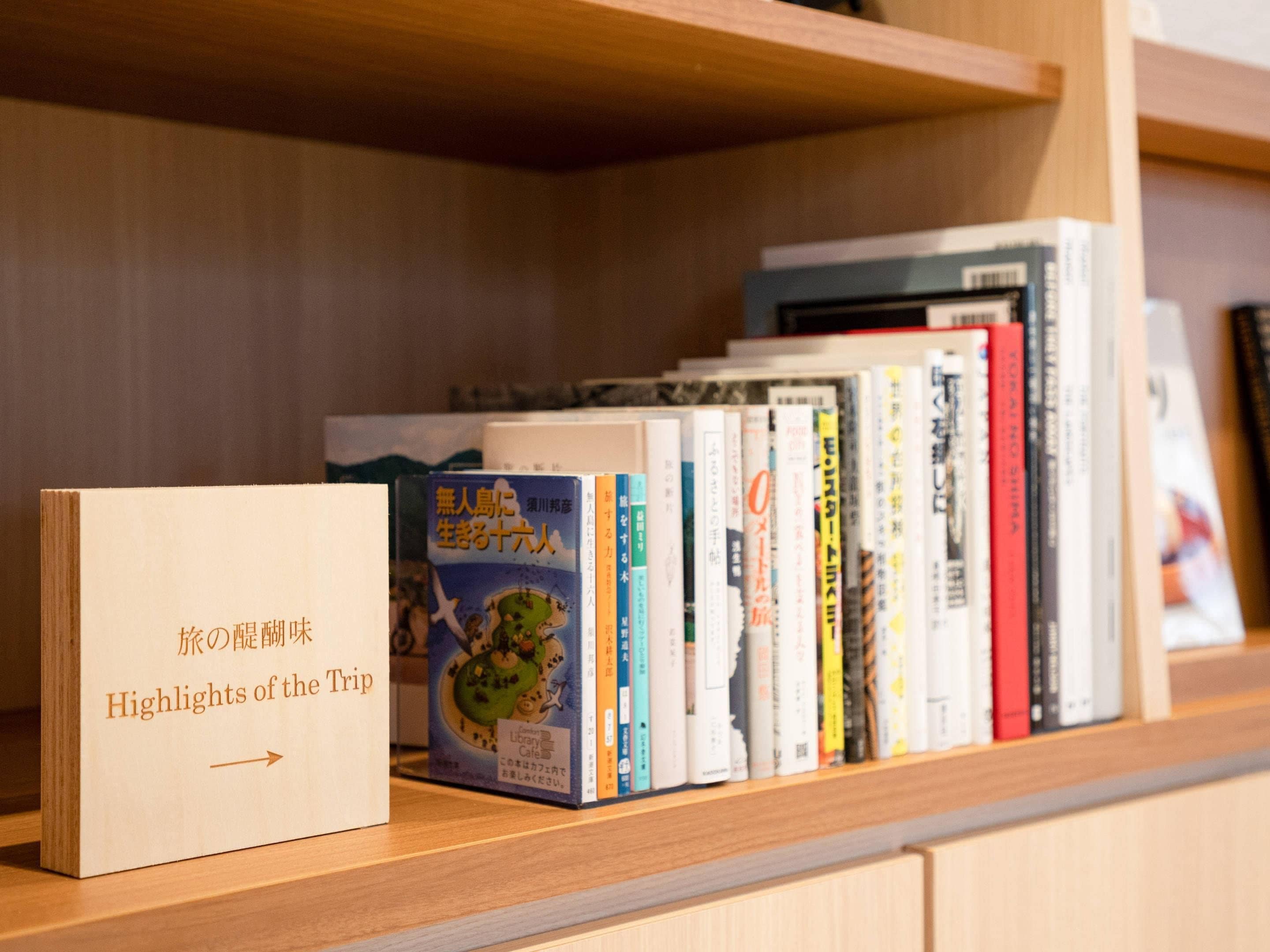 Una biblioteca amb diversos llibres i un cartell amb text en japonès.