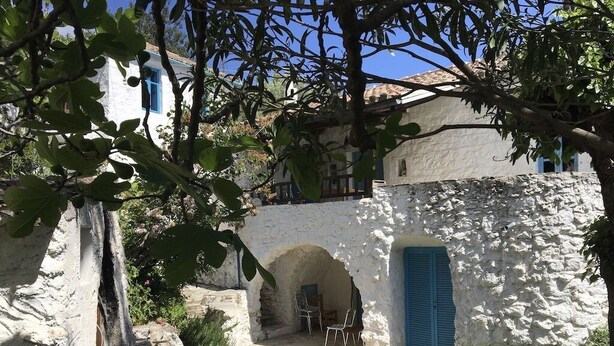 A traditional stone building with a courtyard, featuring a blue door and arched openings. - Arcadia, an idyllic, original, traditional farmhouse (Tyros)