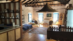 A rustic kitchen with wooden shelves, a dining area with chairs, and a large window. - Arcadia, an idyllic, original, traditional farmhouse (Tyros)