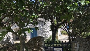 A stone gate with a sign reading "ARCADIA" in front of a white building with blue shutters. - Arcadia, an idyllic, original, traditional farmhouse (Tyros)