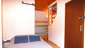 A bedroom with a bunk bed, a wooden door, and a desk with a lamp. - Appartement en Centre Ville Avec Terrasse Exposée Ouest (Cauterets)