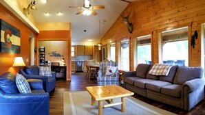 Un intérieur de chalet chaleureux comprenant un espace de vie, un coin repas et une cuisine.