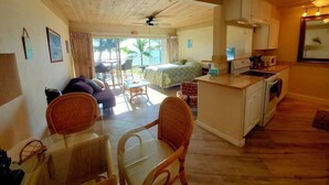 Une pièce confortable avec un canapé, une table à manger, des chaises, un lit et un coin cuisine.