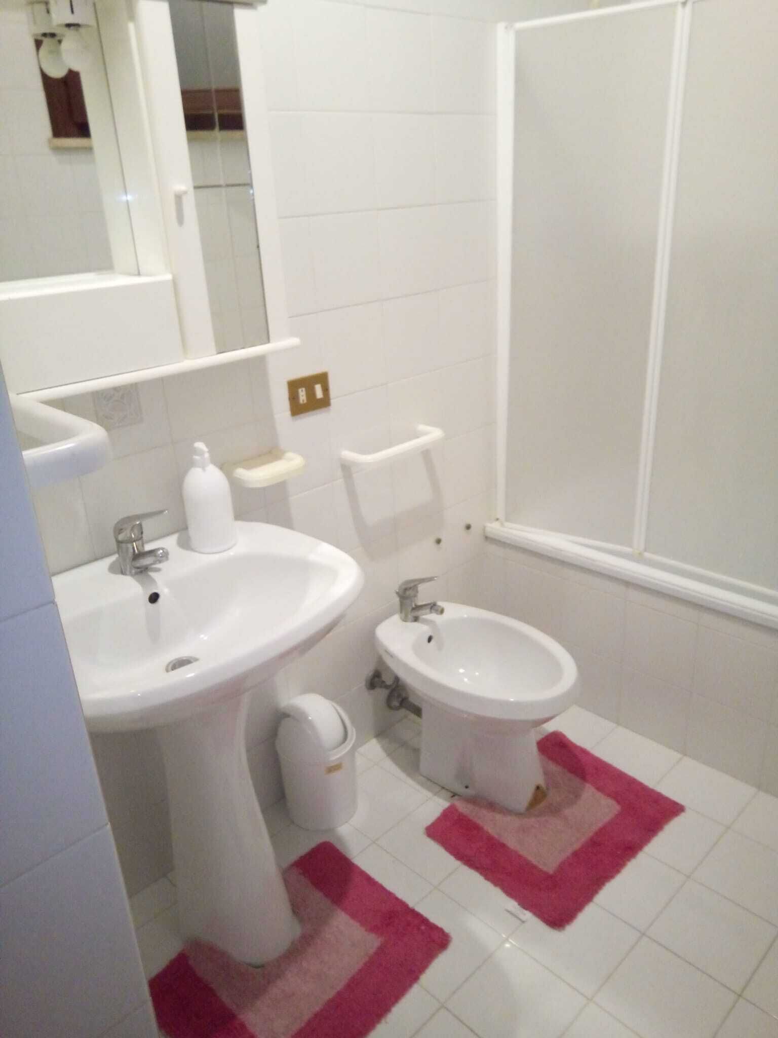 Een bad/douchecombinatie, een haardroger, handdoeken, zeep