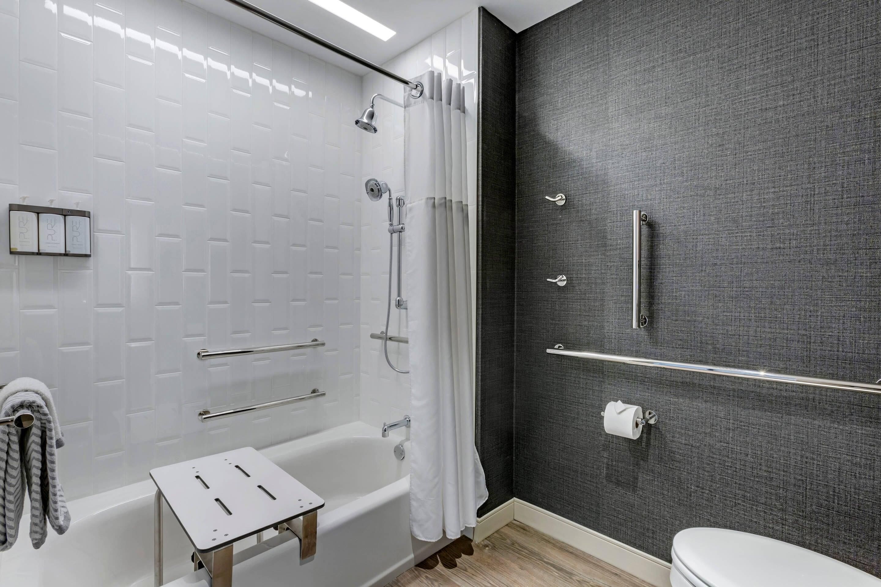 A bathroom with a bathtub, shower, and toilet.