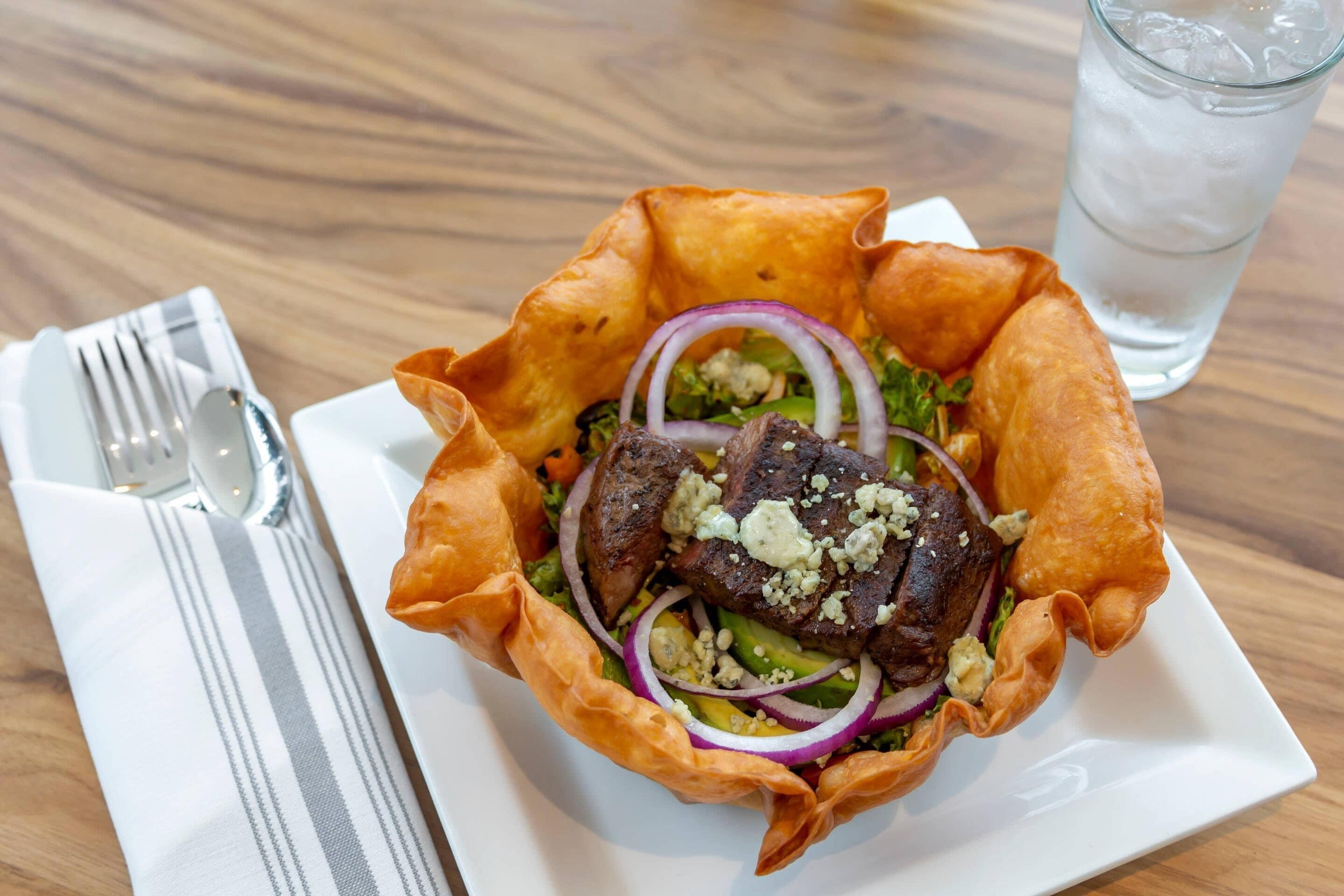 Un repas composé de viande, de légumes et d’une boisson, servi sur une table.