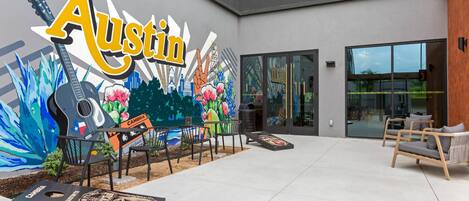 Une cour intérieure ornée d’une fresque murale, dotée d’un espace pour s’asseoir à l’extérieur et d’une enseigne indiquant « Austin ».