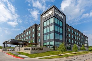 A modern building with the name 'CAMBRIA' prominently displayed on the facade. - Cambria Hotel Austin Airport (Austin)