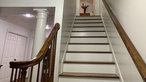 Una escalera con barandas de madera y paredes blancas.