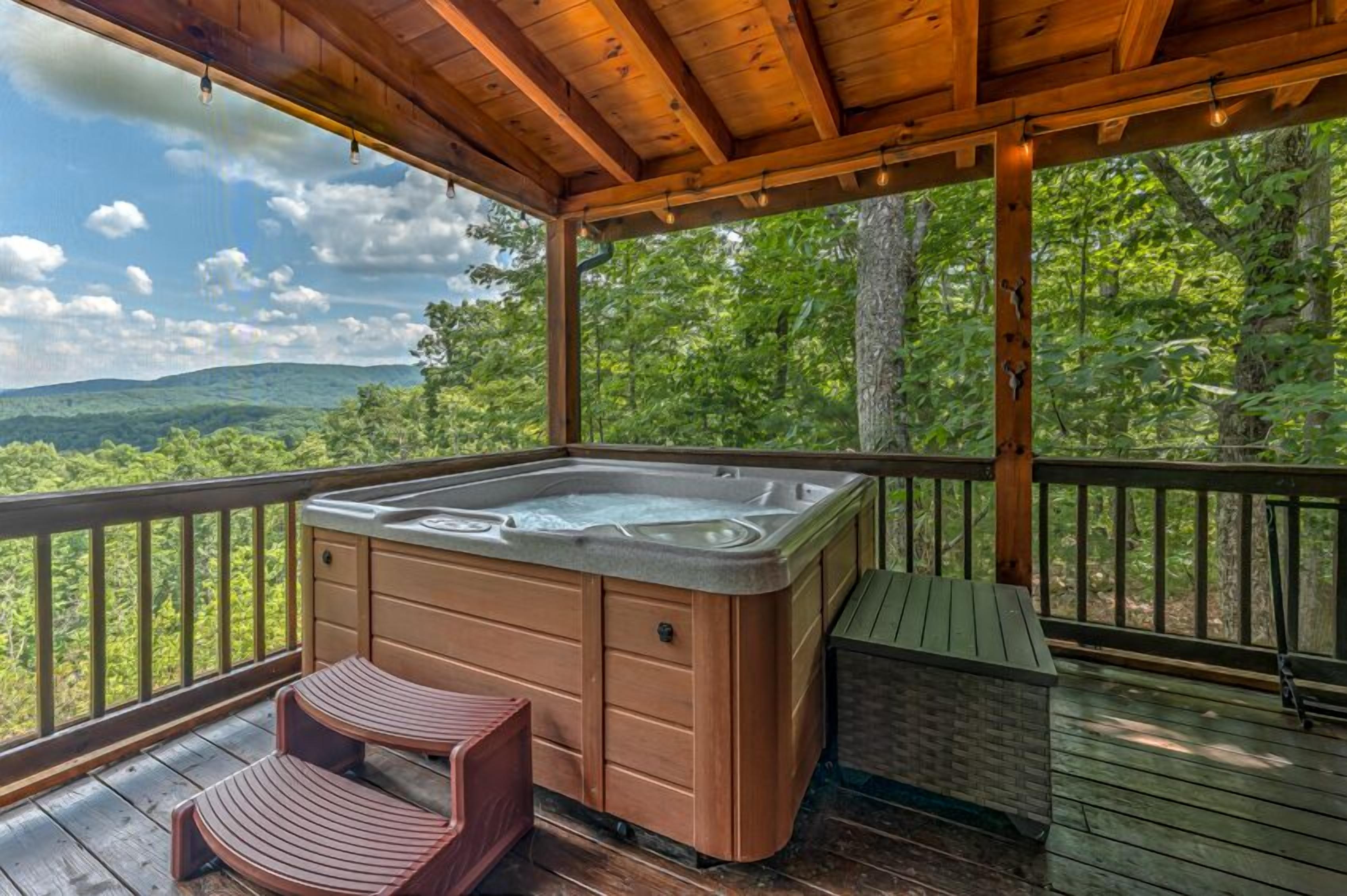 A hot tub on a wooden deck with a view of a forested landscape.