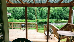 A wooden deck with a view of a river and forest.