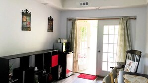 A room with a black and red bookshelf, a small table with a chair, and a door leading outside. - Private, Sanitized Loft, with Discounts Sleeps 2 (Lynchburg)