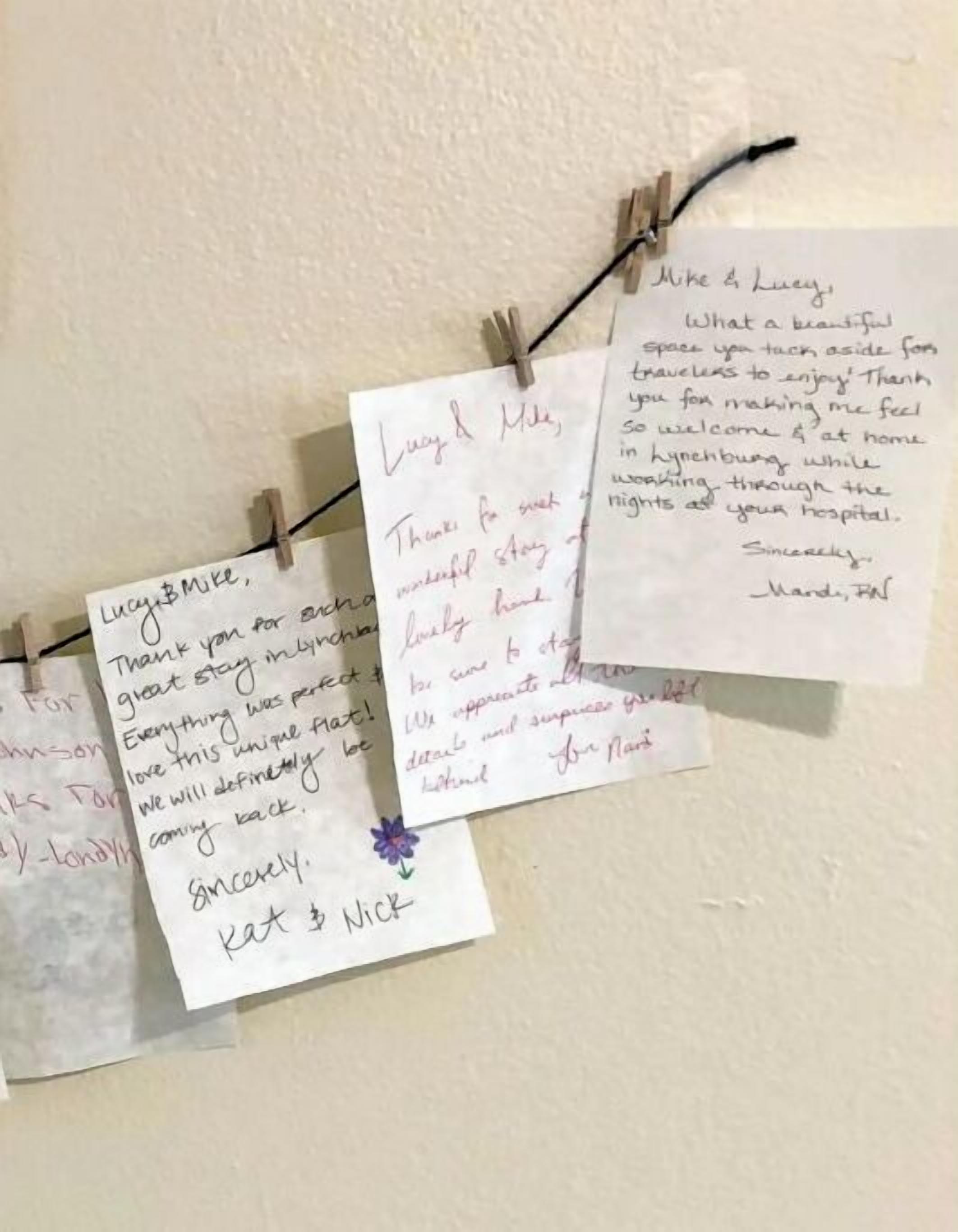 Una pared con varias notas escritas a mano sujetas a un hilo.