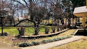 A landscaped garden with a stone pathway, various shrubs, and trees.